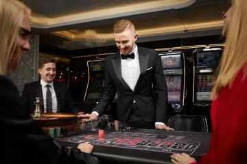 A stylish woman beside vibrant slot machines displaying glowing sevens, showcasing the variety of top slots at KKBDT.